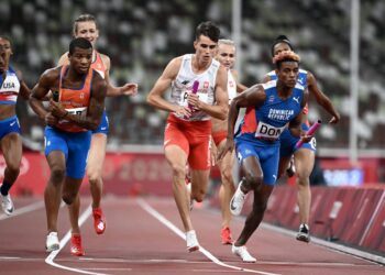 Netherlands' Ramsey Angela (L), Poland's Kajetan Duszynski (C) and Dominican Republic's Alexander Ogando Bautista compete in  the mixed 4x400m relay final during the Tokyo 2020 Olympic Games at the Olympic Stadium in Tokyo on July 31, 2021. (Photo by Jewel SAMAD /