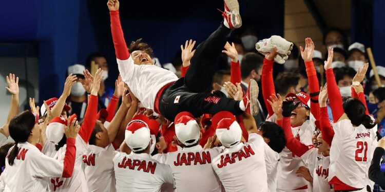 Japan's head coach Reika Utsugi (top C) is tossed in the air by her players after their victory in the Tokyo 2020 Olympic Games softball gold medal game between Japan and USA at the Yokohama Baseball Stadium in Yokohama, Japan, on July 27, 2021. (Photo by STR / JIJI PRESS / AFP) / Japan OUT