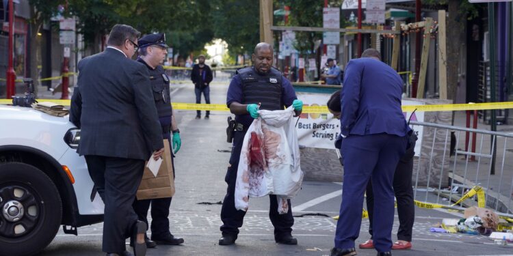 Philadelphia Police investigators work the scene of a fatal overnight shooting on South Street in Philadelphia, Sunday, June 5, 2022. (AP Photo/Michael Perez)